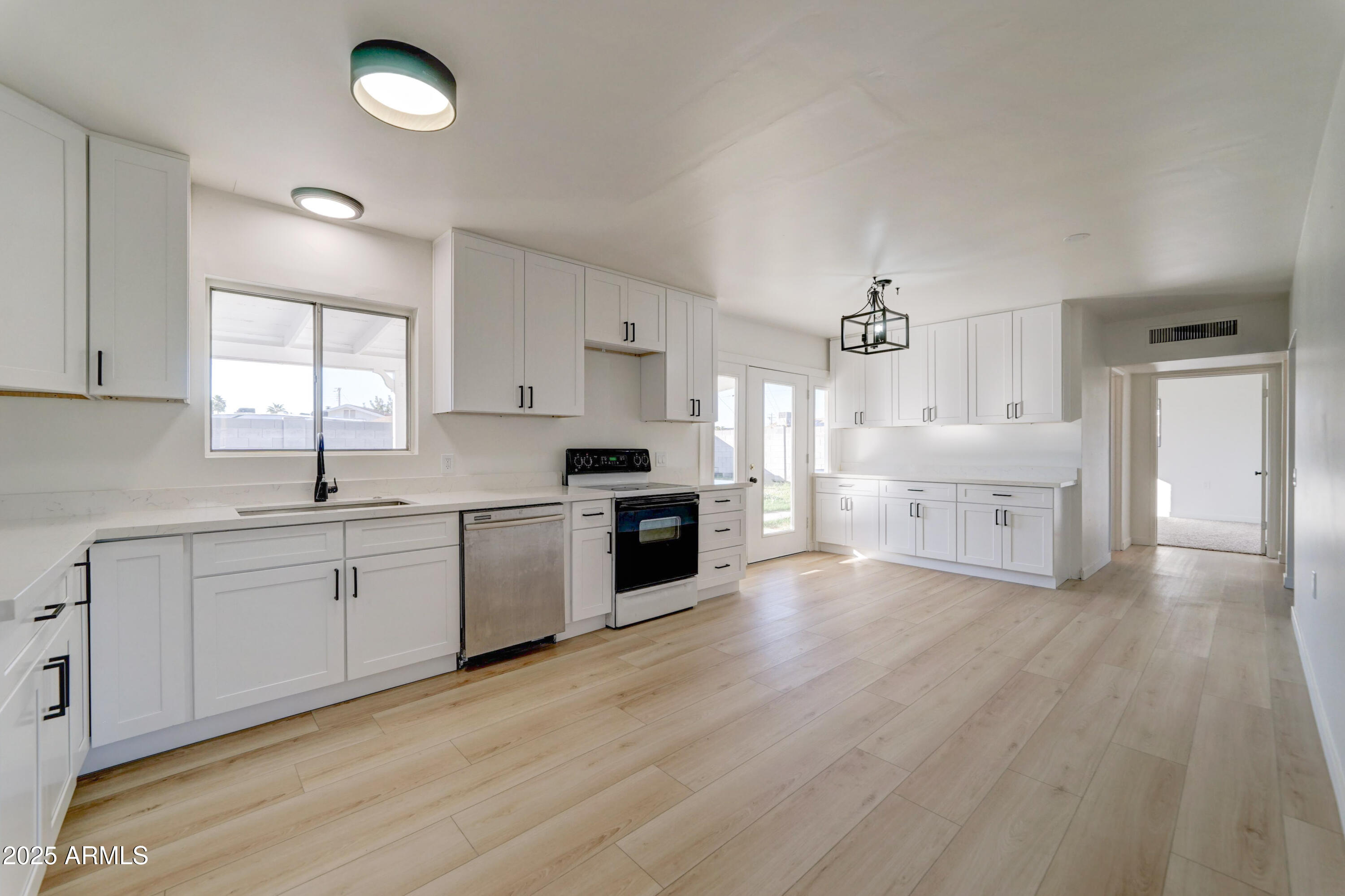 2039 West Northview Avenue Phoenix, AZ 85021 - Photo 8 of 30 a large kitchen with stainless steel appliances granite countertop a stove top oven a sink dishwasher and a refrigerator with wooden floor