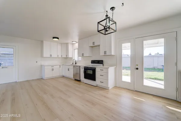 a kitchen with stainless steel appliances a white stove top oven and cabinets