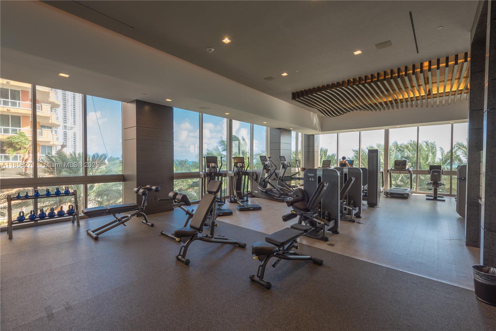 17749 Collins Avenue, Unit 802 Sunny Isles Beach, FL 33160 - Photo 14 of 25 a view of a room with gym equipment and large windows
