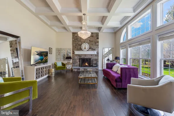 a dining room with wooden floor a chandelier a wooden table and chairs