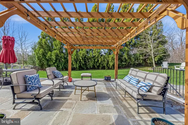 a view of patio with a table and chairs under an umbrella with a big yard