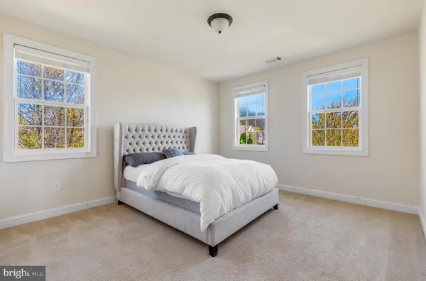 a living room with furniture a rug and kitchen view