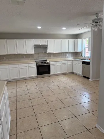 a kitchen with stainless steel appliances cabinets a sink and a stove
