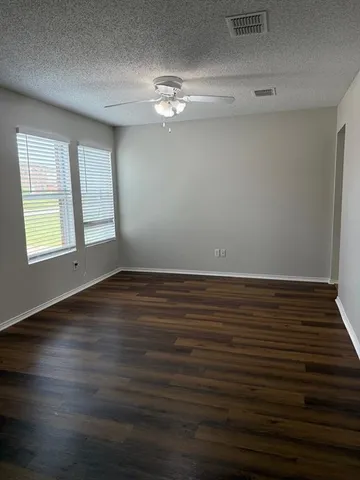 a view of a room with wooden floor and chandelier fan