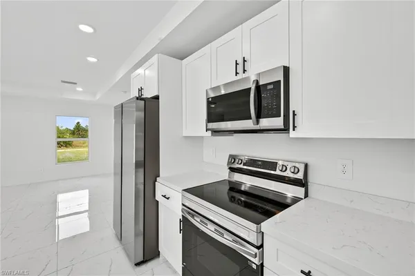 a kitchen with stainless steel appliances a stove microwave and refrigerator