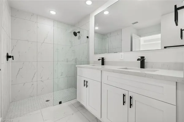 a bathroom with a shower sink and mirror