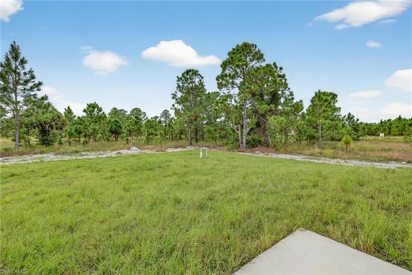 a view of a green field with wooden fence