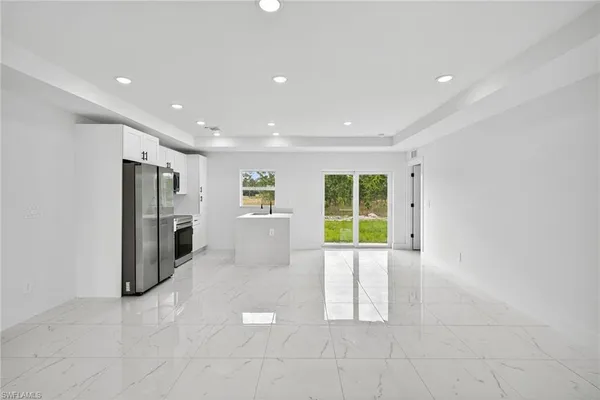 a view of an empty room with a fireplace and a window
