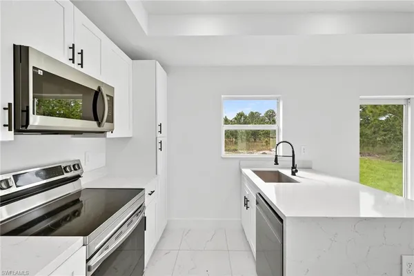a kitchen with a sink stove and microwave