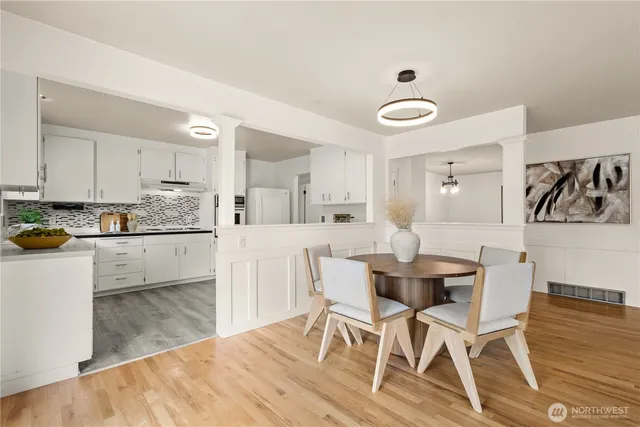 a kitchen with a dining table chairs and white cabinets