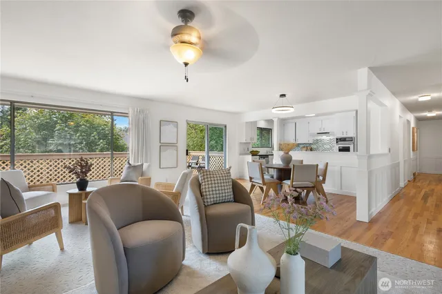 a living room with furniture wooden floor and a large window