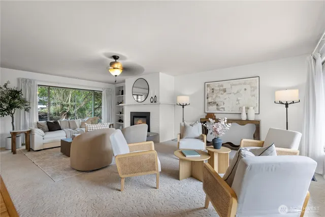 a living room with furniture a fireplace and potted plants