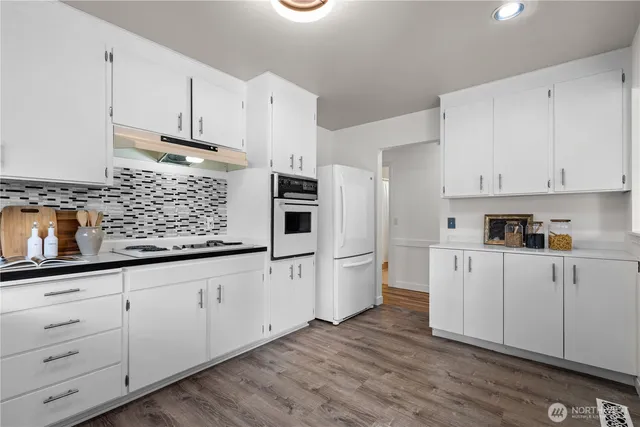 a kitchen with granite countertop white cabinets and white appliances