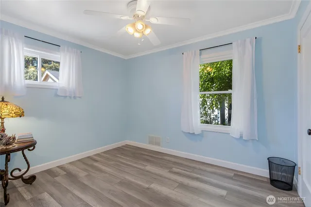 a view of a bedroom with wooden floor and a window