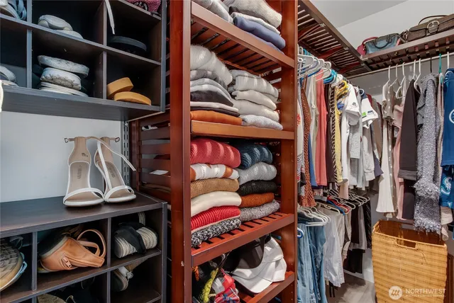 a view of walk in closet with clothes and shoes
