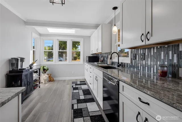 a kitchen with granite countertop lots of counter top space and wooden floor