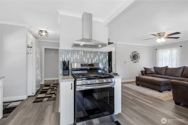 a kitchen with granite countertop a stove and a wooden floors