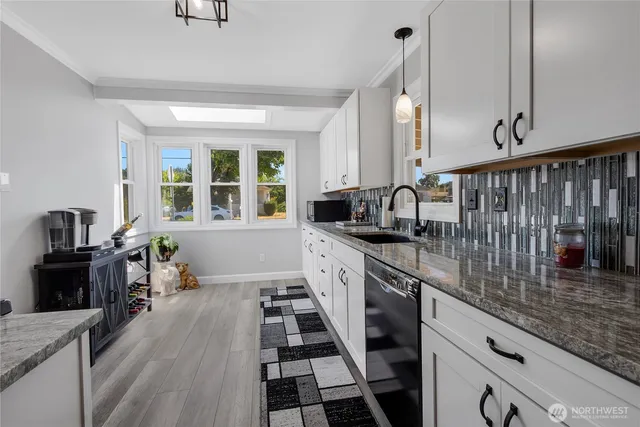 a kitchen with granite countertop lots of counter top space and wooden floor