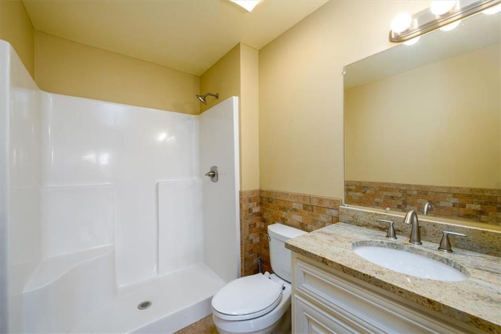 725 County Farm Road Jefferson, GA 30549 - Photo 29 of 43 a bathroom with a granite countertop sink a toilet and shower