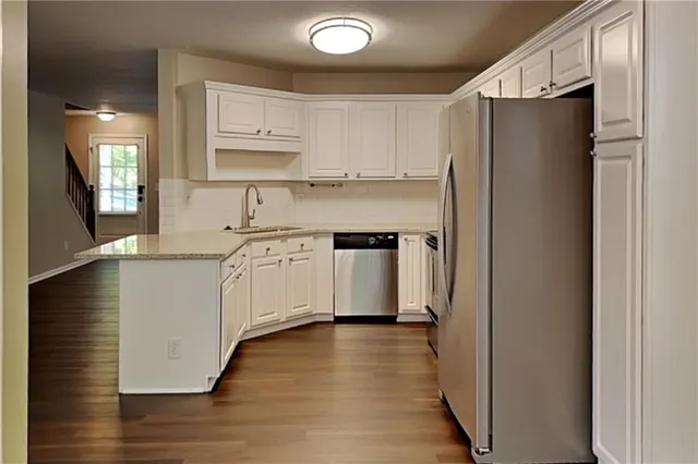a kitchen with stainless steel appliances a refrigerator sink and cabinets