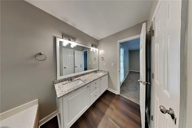 a bathroom with a granite countertop sink a mirror and a vanity