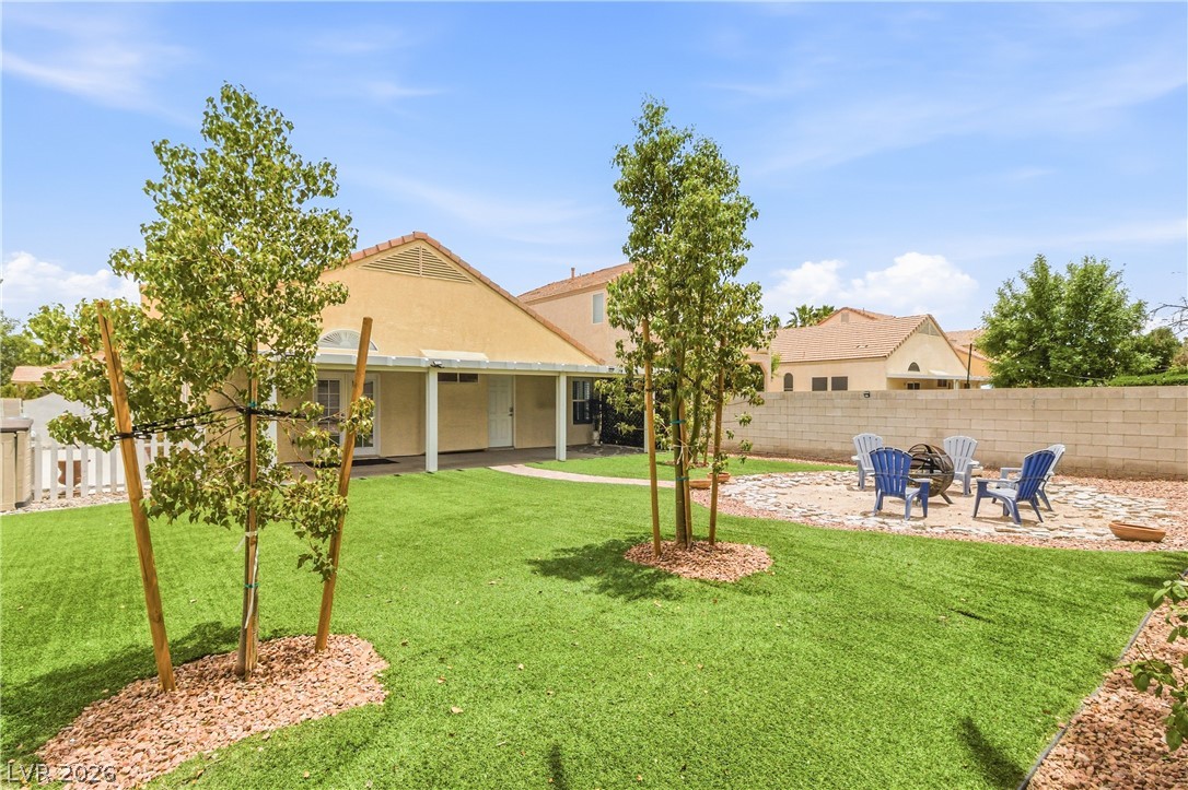 9523 Observer Street Las Vegas, NV 89123 - Photo 37 of 42 Green landscaping and a fire pit invite outdoor gatherings in this appealing backyard.