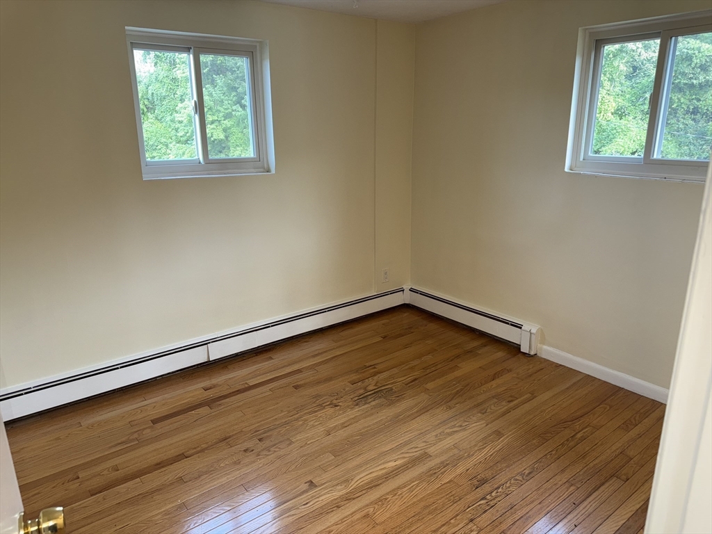 40 Westgate Road, Unit 5 Chestnut Hill, MA 02467 - Photo 20 of 33 an empty room with wooden floor and windows