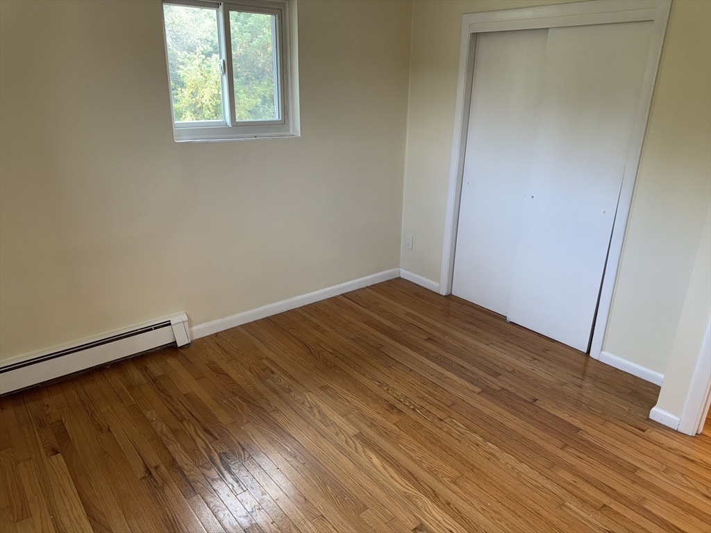 40 Westgate Road, Unit 5 Chestnut Hill, MA 02467 - Photo 21 of 33 an empty room with wooden floor and windows