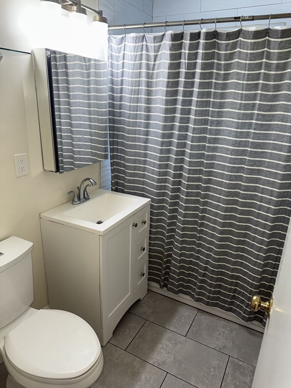 40 Westgate Road, Unit 5 Chestnut Hill, MA 02467 - Photo 23 of 33 a bathroom with a toilet a sink a mirror and shower curtain