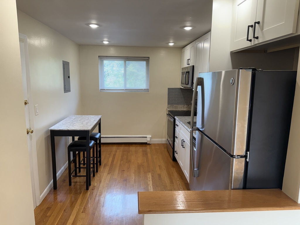 40 Westgate Road, Unit 5 Chestnut Hill, MA 02467 - Photo 4 of 33 a kitchen with a refrigerator wooden floor and a dining table