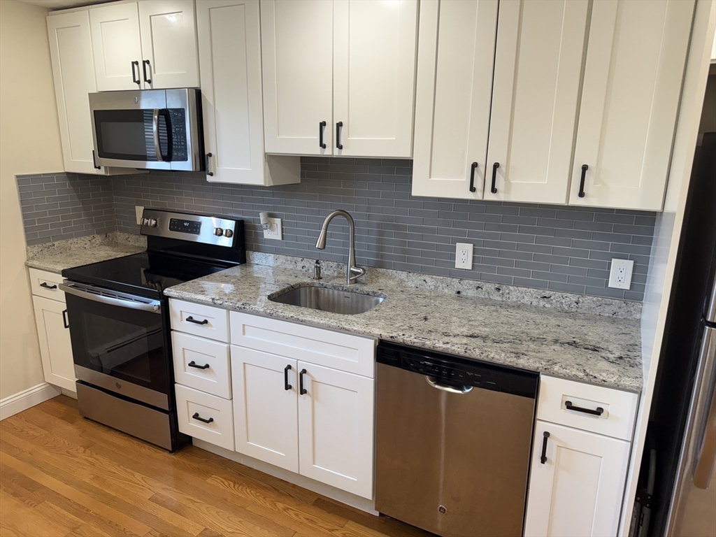40 Westgate Road, Unit 5 Chestnut Hill, MA 02467 - Photo 7 of 33 a kitchen with granite countertop a sink stove and microwave