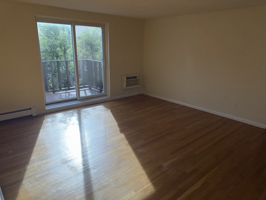 40 Westgate Road, Unit 5 Chestnut Hill, MA 02467 - Photo 10 of 33 a view of an empty room with wooden floor and a window