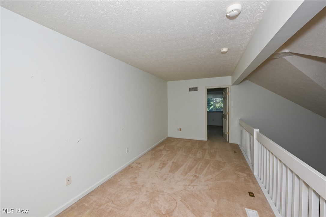 4212 Castle Ridge Akron, OH 44321 - Photo 32 of 44 Additional living space featuring light carpet, a textured ceiling, and baseboards