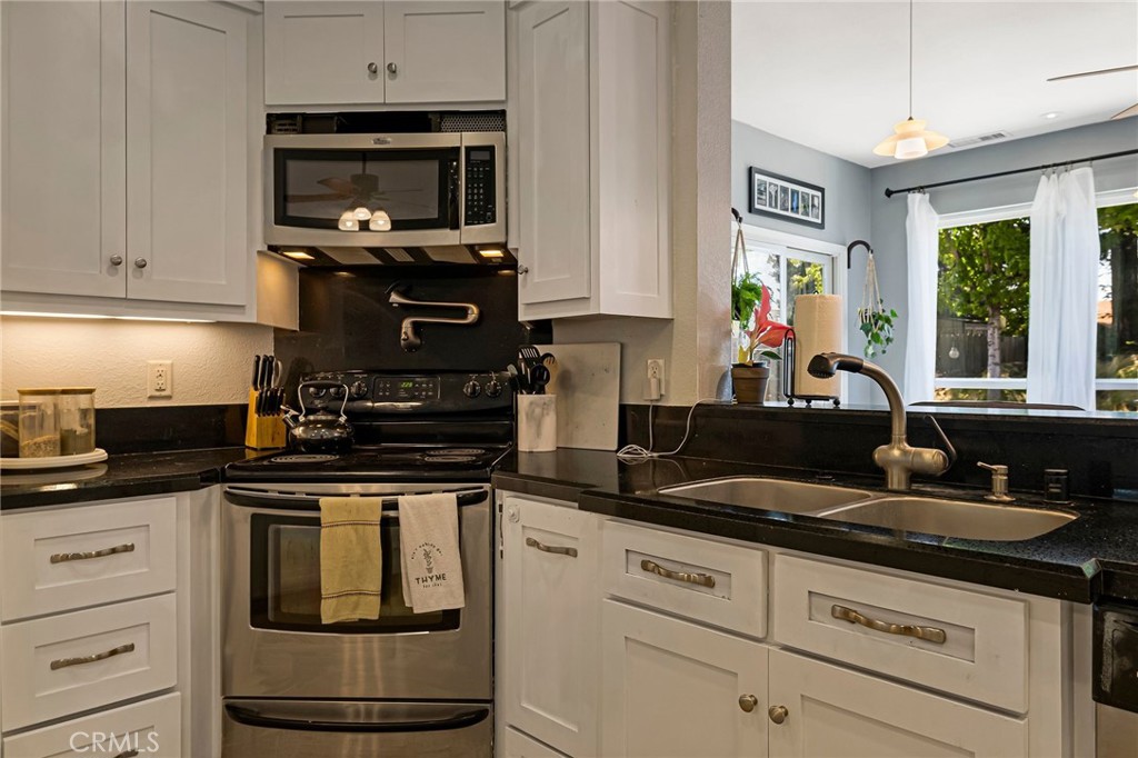 13 Avante Way Chico, CA 95973 - Photo 16 of 58 a kitchen with granite countertop white cabinets and stainless steel appliances