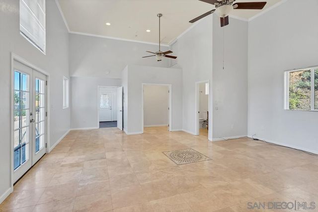 a kitchen with stainless steel appliances granite countertop a refrigerator a sink dishwasher a stove and white countertops with wooden floor