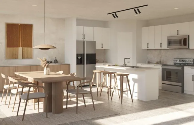 a kitchen with stainless steel appliances kitchen island granite countertop a sink a stove a table and chairs