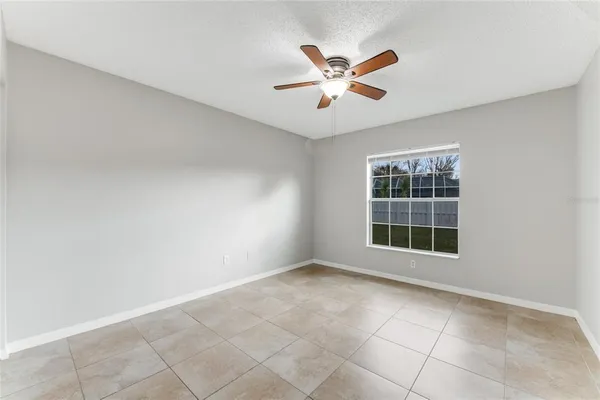 an empty room with windows and fan