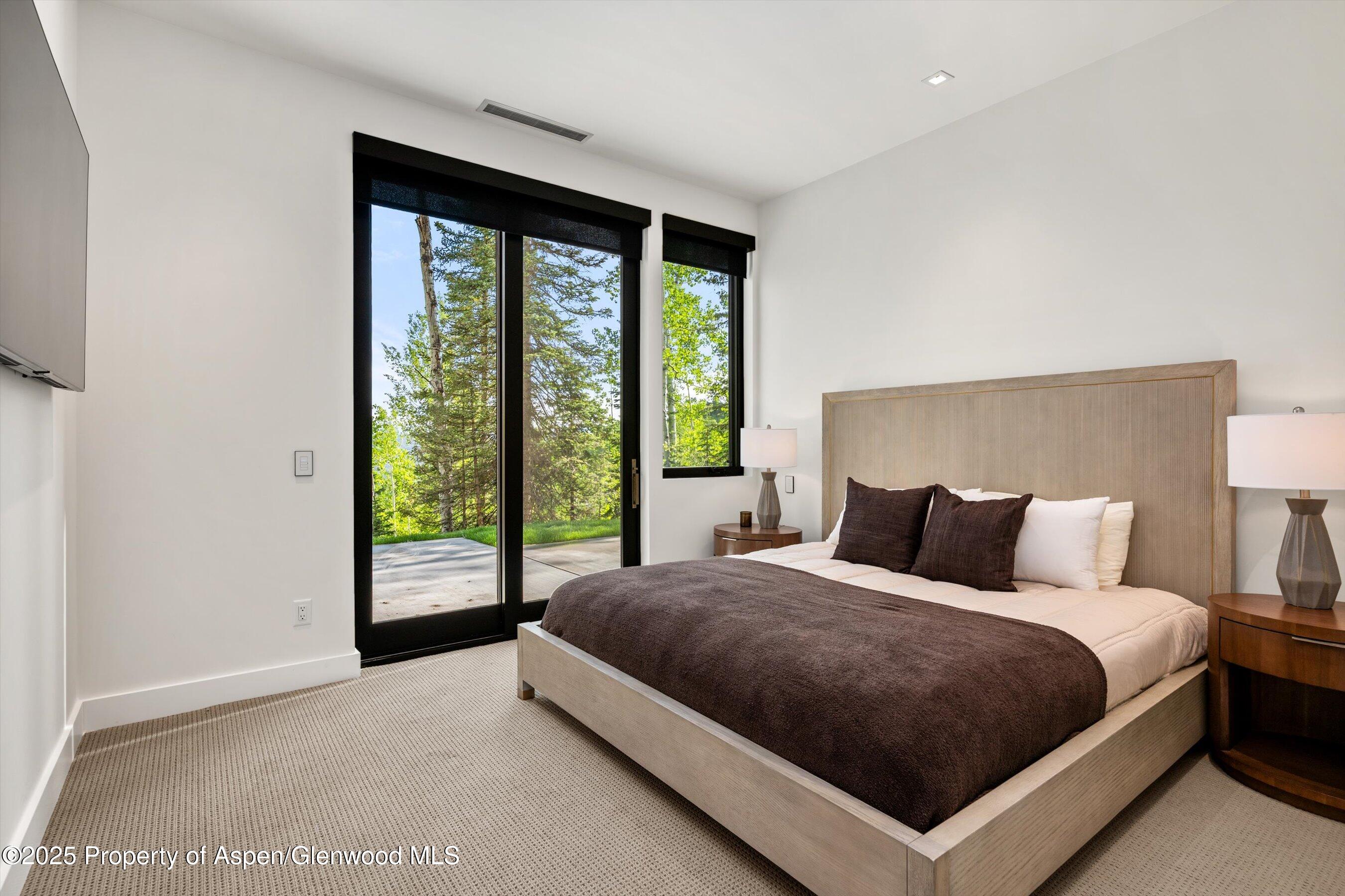1234 Wood Road Snowmass Village, CO 81615 - Photo 51 of 66 a bedroom with a large bed and a large window