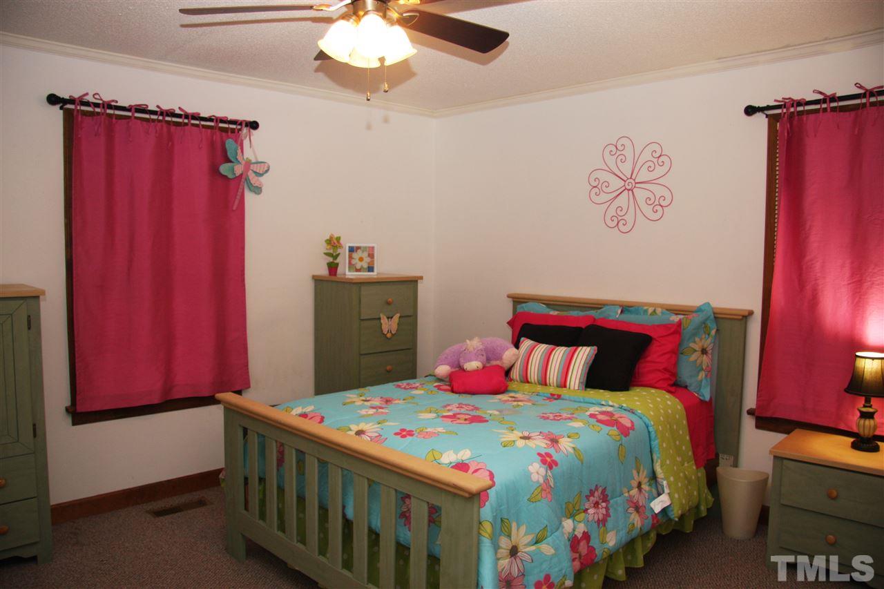 1825 Rc Watson Road Wendell, NC 27591 - Photo 11 of 18 a bedroom with a bed and a chandelier