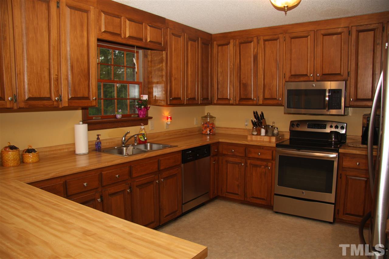 1825 Rc Watson Road Wendell, NC 27591 - Photo 6 of 18 a kitchen with stainless steel appliances wooden cabinets a stove top oven a sink and dishwasher