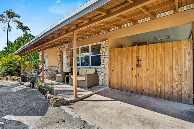 a backyard of a house with wooden fence and a large tree