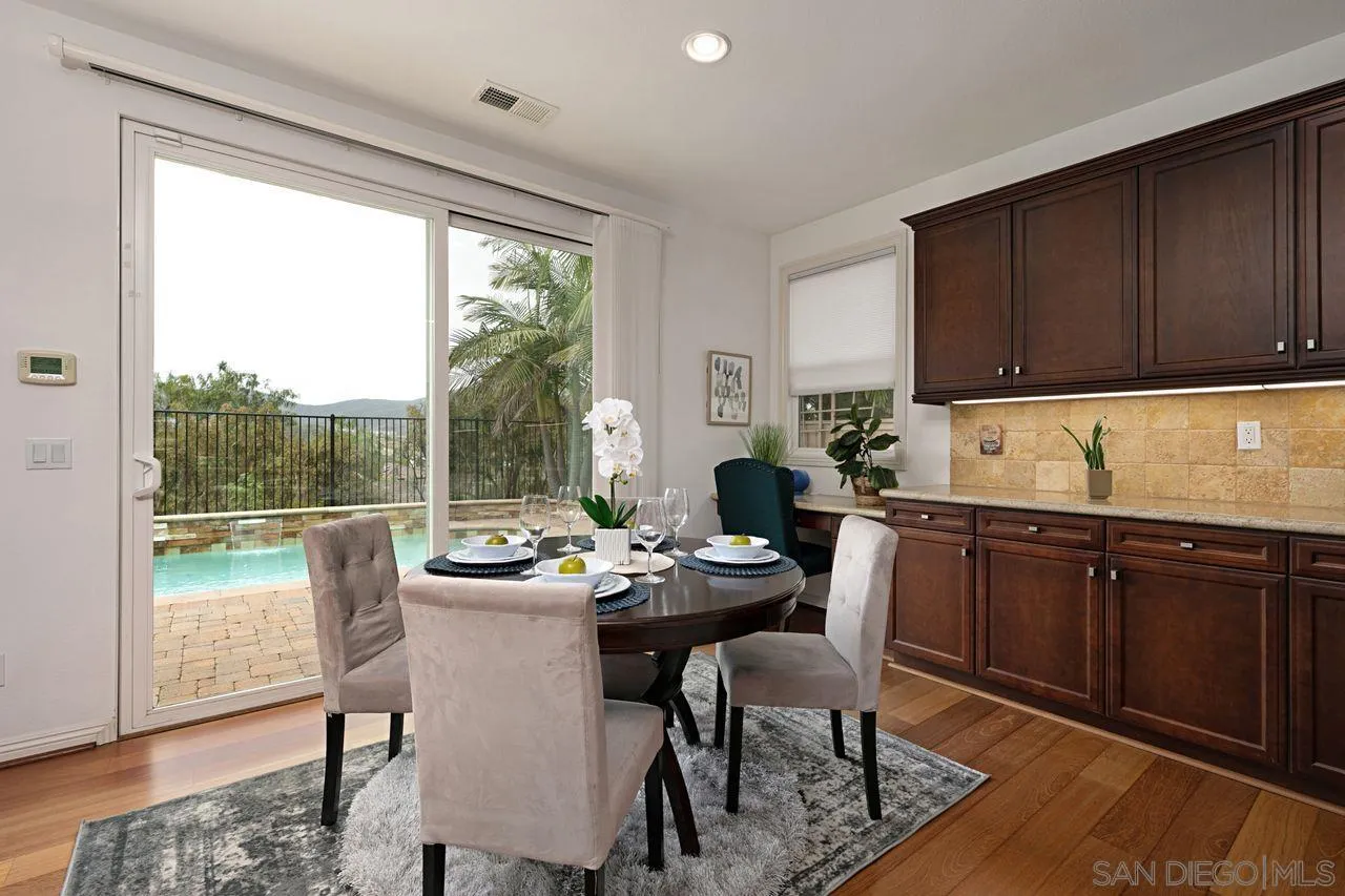 16076 Cayenne Ridge Road San Diego, CA 92127 - Photo 15 of 43 a kitchen with a table chairs and wooden cabinets
