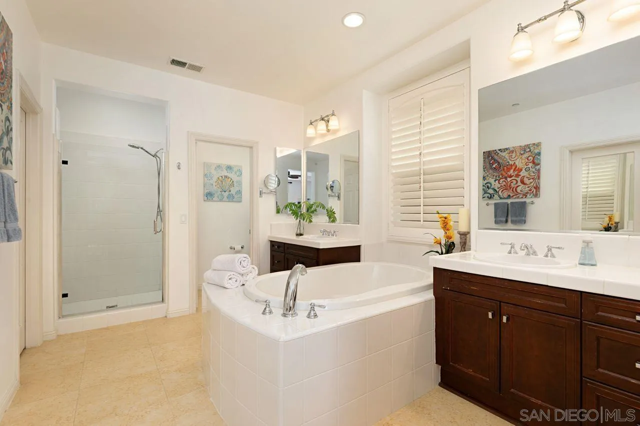 16076 Cayenne Ridge Road San Diego, CA 92127 - Photo 21 of 43 a bathroom with a double vanity sink a mirror and a shower