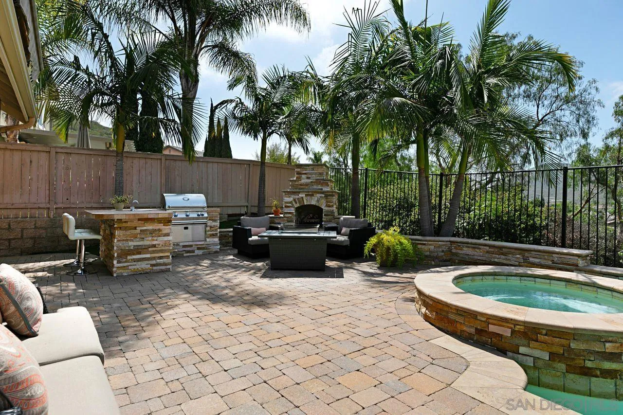 16076 Cayenne Ridge Road San Diego, CA 92127 - Photo 35 of 43 a view of a backyard with swimming pool table and chairs