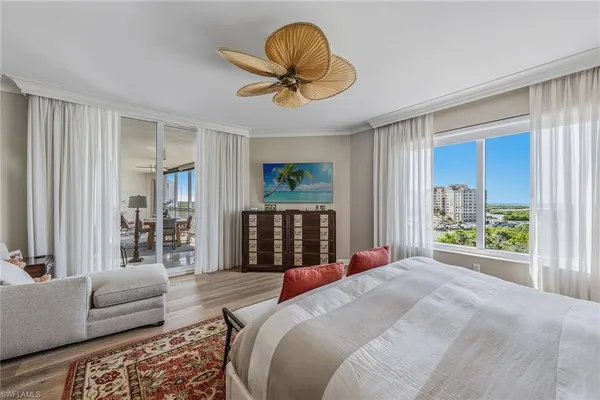 a bedroom with a bed and a large window