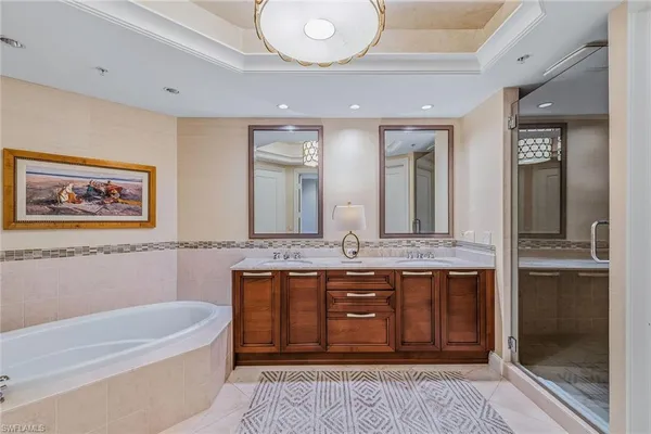 a bathroom with a granite countertop tub sink and mirror