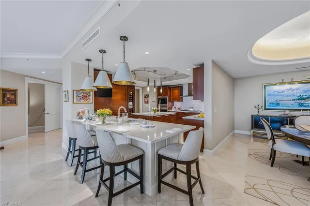 a kitchen with stainless steel appliances kitchen island granite countertop a table and chairs in it