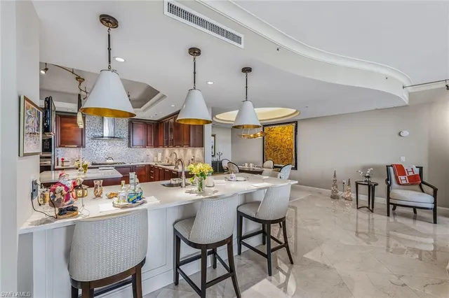 a kitchen with a dining table chairs sink and white cabinets