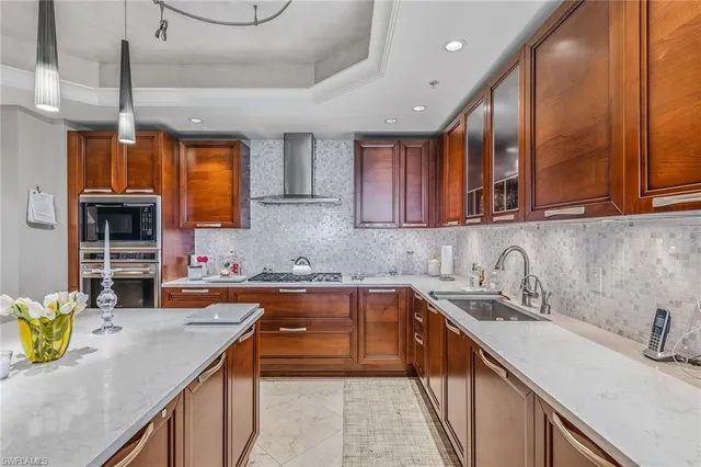 a kitchen with stainless steel appliances granite countertop a sink a stove counter space and cabinets