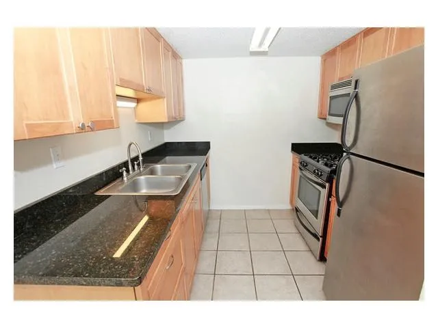 a kitchen with stainless steel appliances granite countertop a sink refrigerator and microwave
